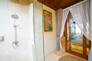 a bathroom with a shower and a glass door at Ubu Villa Sujiva in Ngaglik