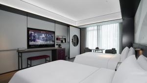 Voodi või voodid majutusasutuse JOYA Hangzhou Qianjiang New Town toas +37 fotot