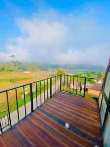 a wooden deck with a view of a field at Hiranya frame house in Pattipola