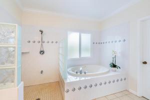 a white bathroom with a tub and a window at Hale Cassia in Princeville +30 photos