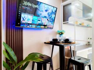 a room with a table and two stools and a tv at Cebu stays-Saekyung 956 Condominium unit 1209 in Lapu Lapu City