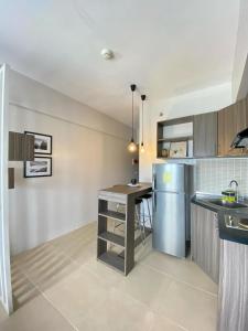 Una cocina con un refrigerador y una mesa dentro. en Lovely CondoStay Cebu T2-25, en Cebú