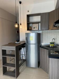 una cocina con refrigerador de acero inoxidable y encimera en Lovely CondoStay Cebu T2-25, en Cebú