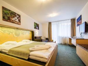 
a hotel room with a bed and a desk at Hotel Diery in Terchová

