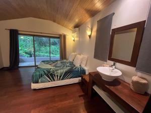 莫雷阿Moorea Temae Villa walking dist beach and golf的配有床、水槽和镜子的浴室