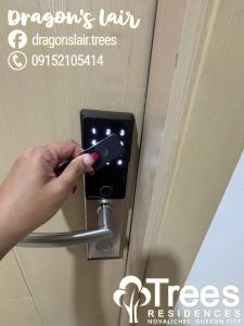 a person unlocking a door with a cell phone at 1-bedroom Condo Unit with PS5, Netflix & Pool near SM Fairview in Manila