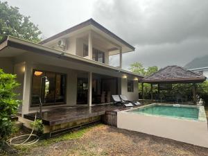 莫雷阿Moorea Temae Villa walking dist beach and golf的一座带游泳池和房子的度假屋