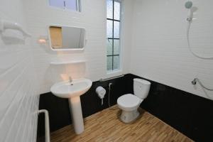 ルーイにあるบ้านสวนดงのトイレと洗面台を備えた白いバスルーム +13枚の写真
