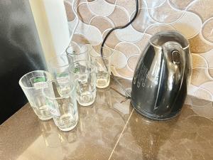 a tea kettle and glasses on a table at Perling Muji 3 Bedrooms Suites 6 pax Paradigm Mall in Johor Bahru