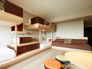 ein kleines Zimmer mit zwei Etagenbetten und einem Tisch in der Unterkunft Hotel Universal Port in Osaka