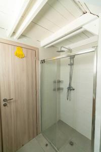 a shower with a glass door in a bathroom at Seaside Glow in Schinias