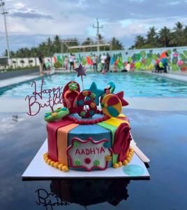 a birthday cake in front of a swimming pool at Hotel City Square in Dindigul +19 photos