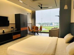 a bedroom with a bed and a living room at Hotel City Square in Dindigul