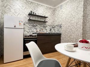 a kitchen with a white refrigerator and a table at Апартаменты стандарт in Pavlodar