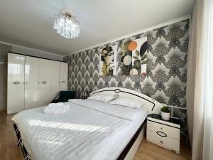 a bedroom with a large white bed with a chandelier at Апартаменты стандарт in Pavlodar