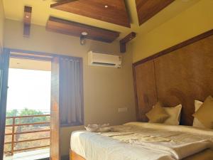 a bedroom with a bed and a large window at Sea Island Resort in Cheruvattūr +81 photos
