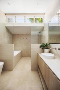 Un baño con lavabo, bañera e inodoro. en Coastal Haven on Witta, en Noosa Heads