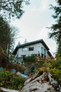 a house sitting on top of a hill at First Light - Waterfront, Hot tub, Sauna, EV in Tofino