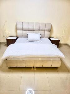 una camera da letto con un letto grande con una grande testiera di Vistahome ad Ajman
