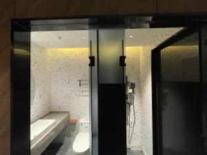 a bathroom with a sink and a toilet and a mirror at Dengba Inn-Shanghai New World Plaza Branch in Shanghai