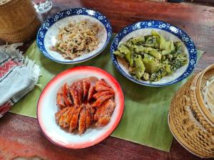 a table with three plates of food on it at Ban Anoulak - Cultural Preservation Village in Nam Bak +20 photos