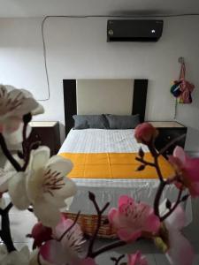 a bedroom with a bed and flowers in the foreground at departamento sisal 1 in Valladolid