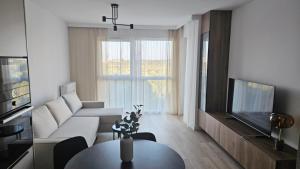 ein Wohnzimmer mit Sofa und Tisch in der Unterkunft Nova Letnica Sea Apartaments in Gdańsk Letnica