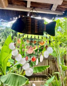 a chandelier made out of shells hanging from a plant at La Palapa Inn Port Barton in San Vicente