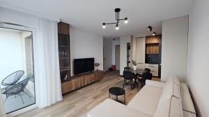 a living room with a white couch and a table at Nova Letnica Sea Apartaments in Gdańsk Letnica