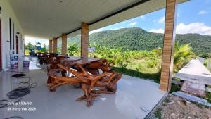 a room with a table with a view of a mountain at Buketree homestay satun in Ban Khok