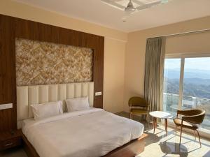 a bedroom with a large bed and a large window at Rudra Villa in Jutogh