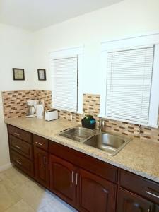 a kitchen counter with a sink and two windows at Vacation Unit is Available for Business and Family Trip in Long Beach