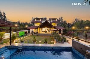 a house with a swimming pool in front of a house at EKOSTAY - Shelby Villa in Panchgani