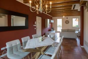 a dining room with a table and white chairs at Wonderful villa on the Garda Lake with private garden in Salò +48 photos