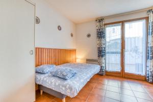 a bedroom with a bed with blue pillows on it at Nid Sympa - plage à 5min à pieds in Saintes-Maries-de-la-Mer