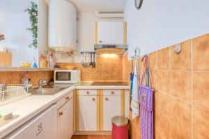 a small kitchen with a sink and a microwave at Nid Sympa - plage à 5min à pieds in Saintes-Maries-de-la-Mer +17 photos