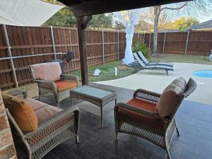 un groupe de chaises et de tables sur une terrasse dans l'établissement Dallas Lakeside Bliss Stay - Private Pool, Air hockey and High speed internet, à Corinth