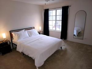 une chambre avec un grand lit blanc et un miroir dans l'établissement Dallas Lakeside Bliss Stay - Private Pool, Air hockey and High speed internet, à Corinth 34 autres photos