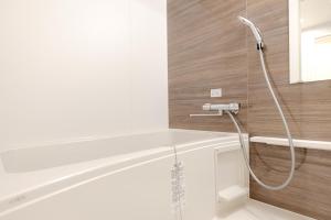 a shower in a bathroom with a shower head at Shinjuku iotele-hatsudai House in Tokyo +120 photos