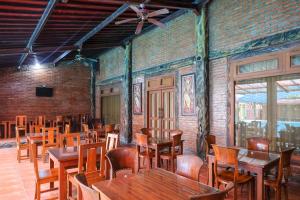 a dining room with wooden tables and chairs at RedDoorz at Savitri Hotel in Yogyakarta