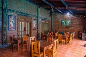 a dining room with wooden tables and chairs at RedDoorz at Savitri Hotel in Yogyakarta