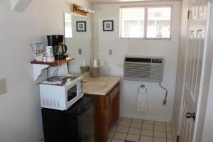a small kitchen with a microwave and a sink at Barewood Inn & Suites in Wofford Heights