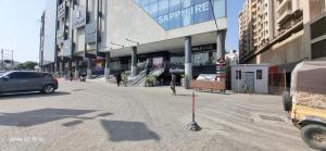 een straat in een stad met een auto geparkeerd voor een gebouw bij One Bedroom studio apartment with kitchen in Karachi