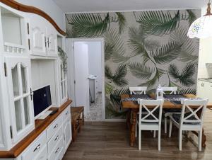 a dining room with a table and chairs and a wall at Apartamentos Camping El Palmar in El Palmar