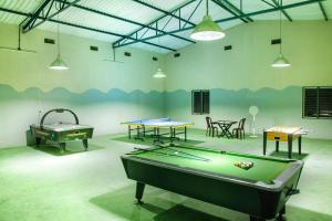 a room with a pool table and ping pong tables at RG Hotels and Resort in Mālūr