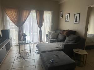 a living room with a couch in front of a window at Kwa Ndosi in Polokwane