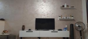 a living room with a television on a white table at SOPHIA Central Studio in Hunedoara