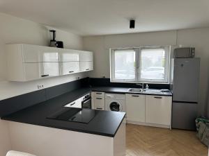 a kitchen with white cabinets and a black counter top at Ferienunterkunft Lutherbaum 4 Zimmer 6 Betten in Worms