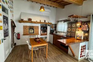una cucina con un tavolo di legno e una sala da pranzo di Alojamento Ponta Negra a Biscoitos