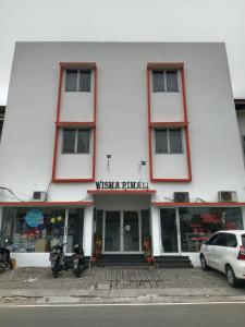 a white building with motorcycles parked in front of it at Hotel Rimadi in Jakarta